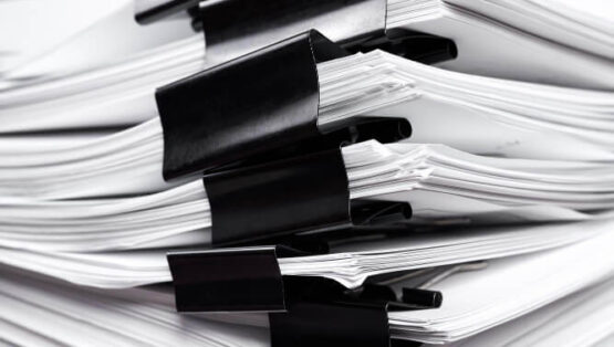 stack-office-papers-some-which-are-fastened-with-black-binders (1)